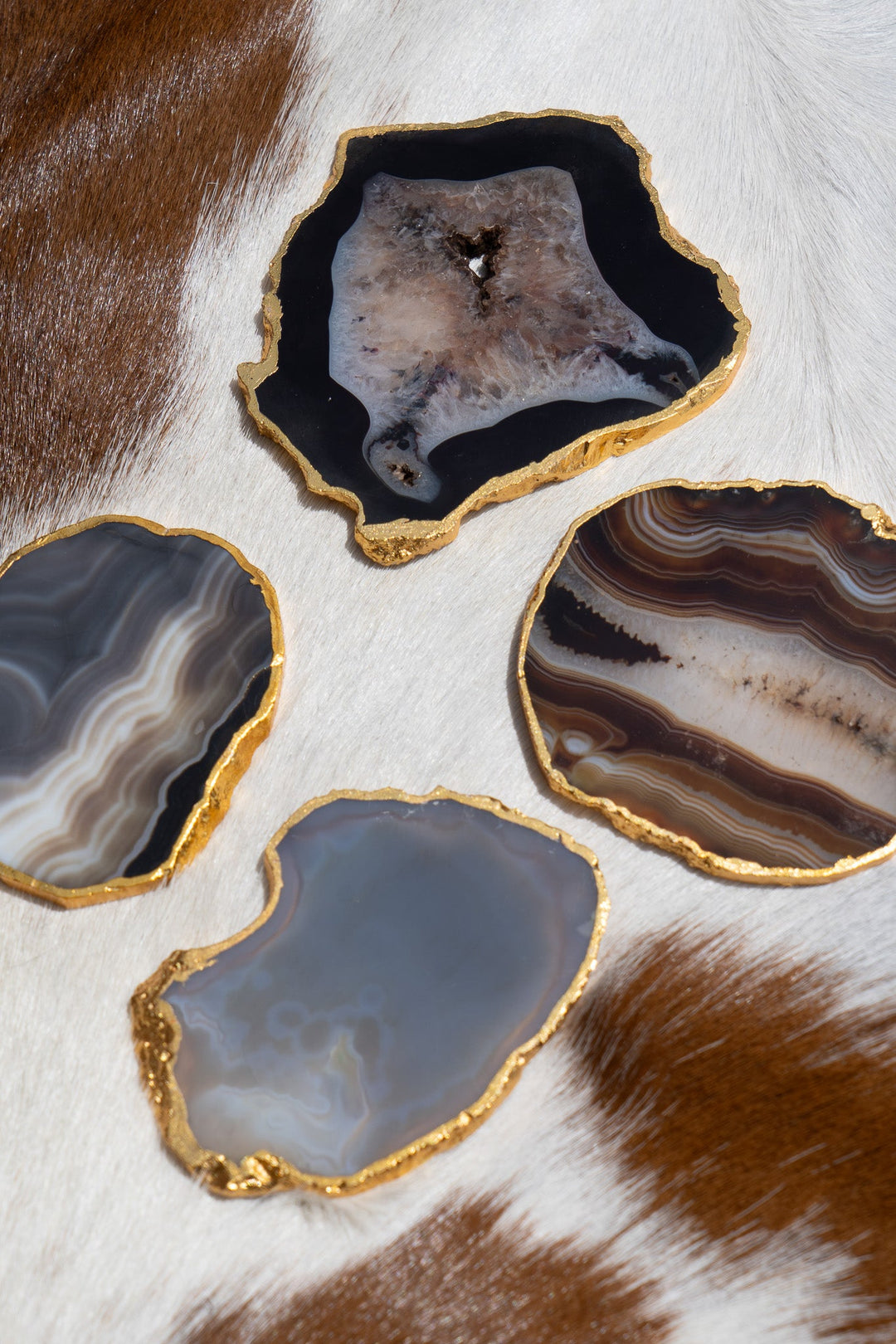 Gold-rimmed agate coasters, dark blue-gray and brown slices with gold border