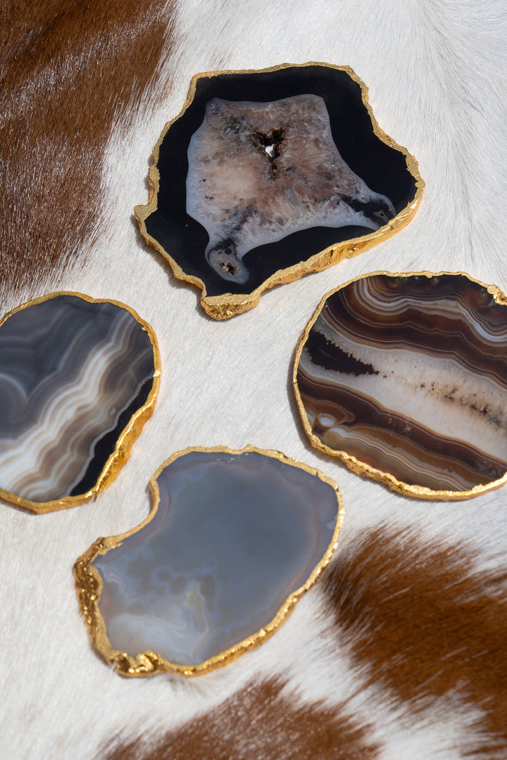 Gold-rimmed agate coasters, dark blue-gray and brown slices with gold border