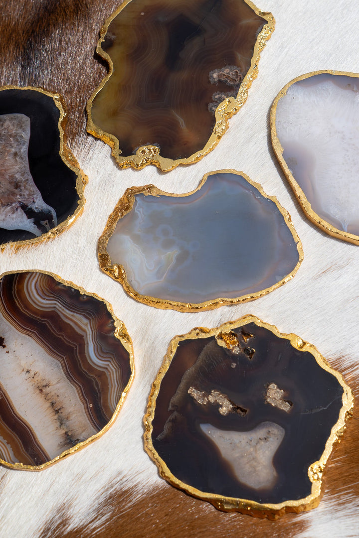 Gold-rimmed agate coasters, mix of brown, blue, and white stone slices