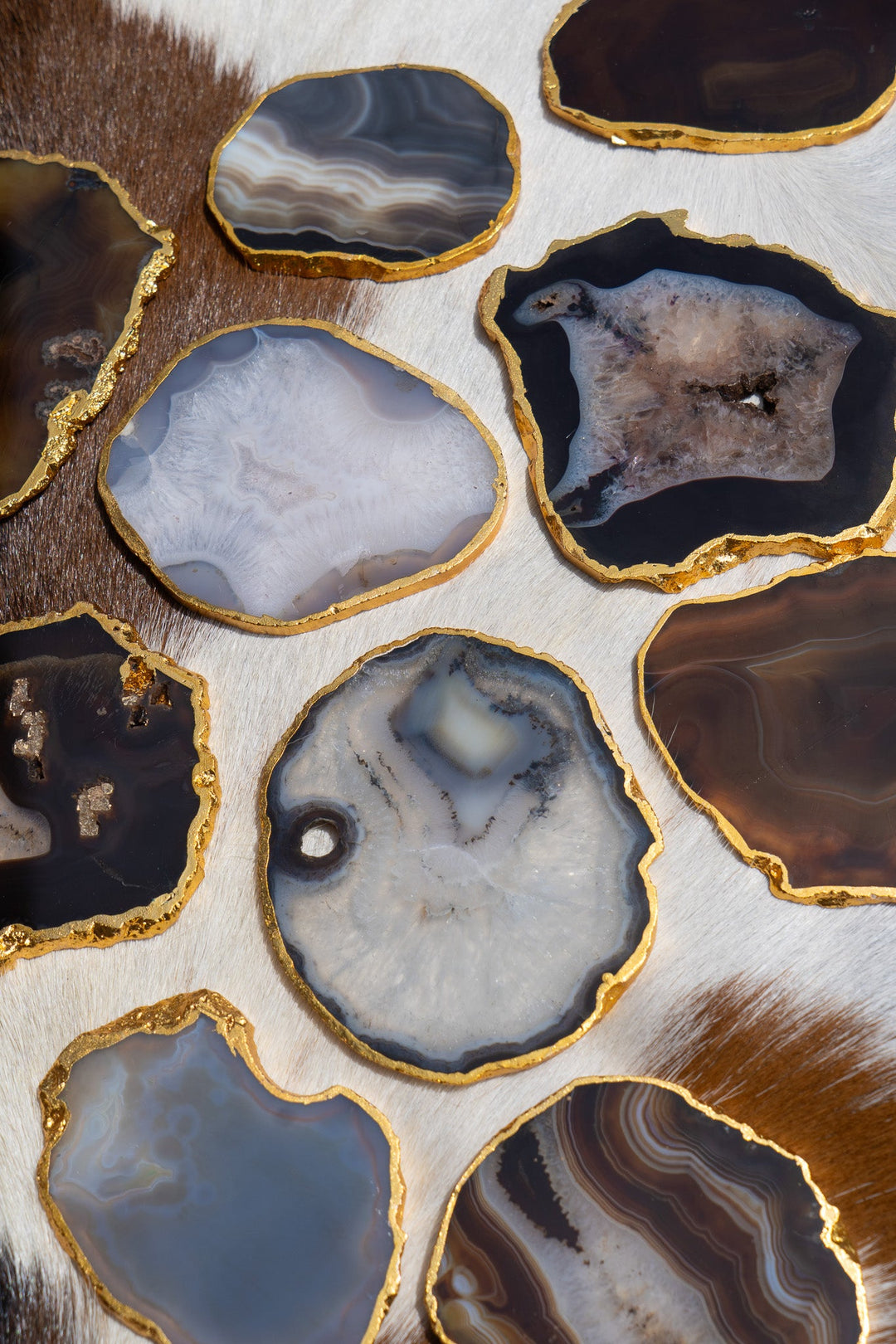 Gold-rimmed agate coasters, light blue and dark stone slices with gold edges