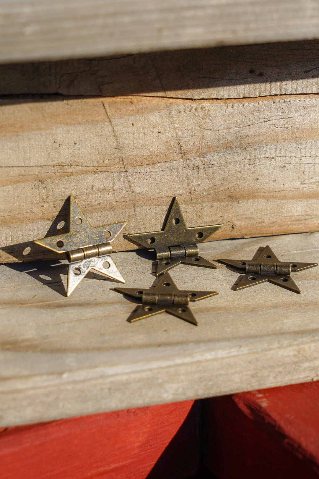 Bronze star hinges attached to wooden panels with visible screw holes