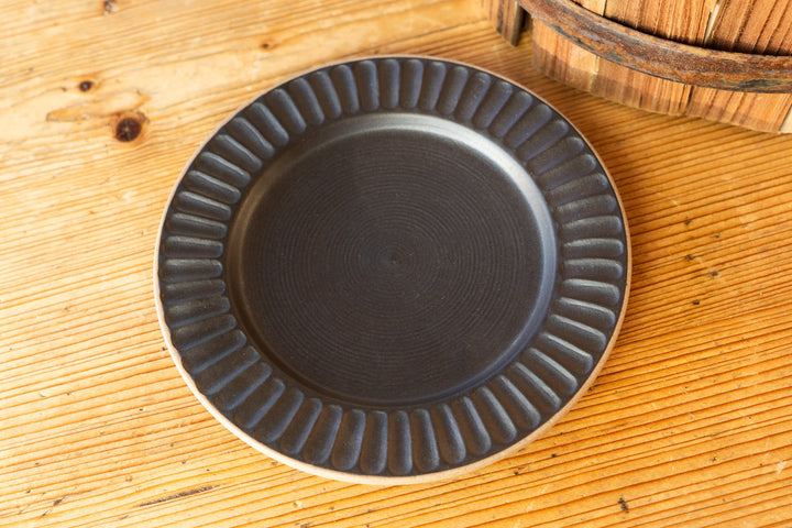 Matching ridged dark saucer with concentric rim texture