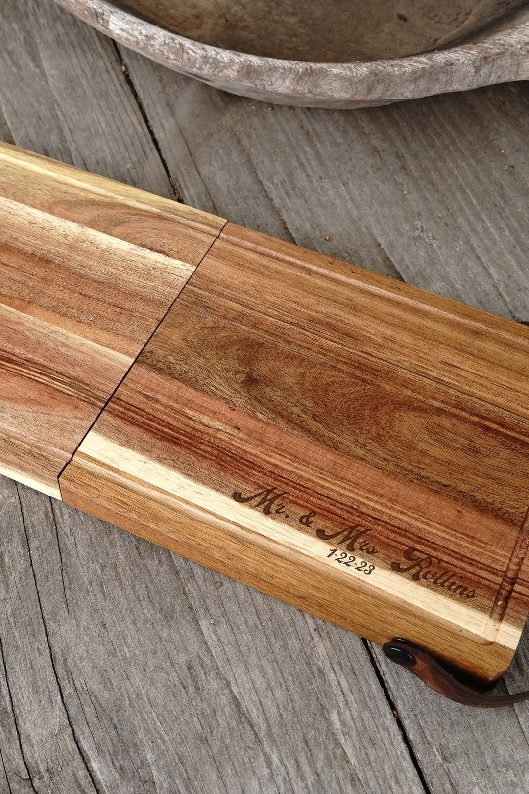 Engraved wooden folding cheese board with brass latch and dark strap