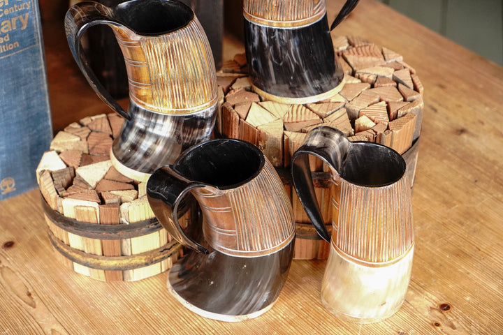 Two-tone horn stein display with several cups, dark handles and light wood-grain banding