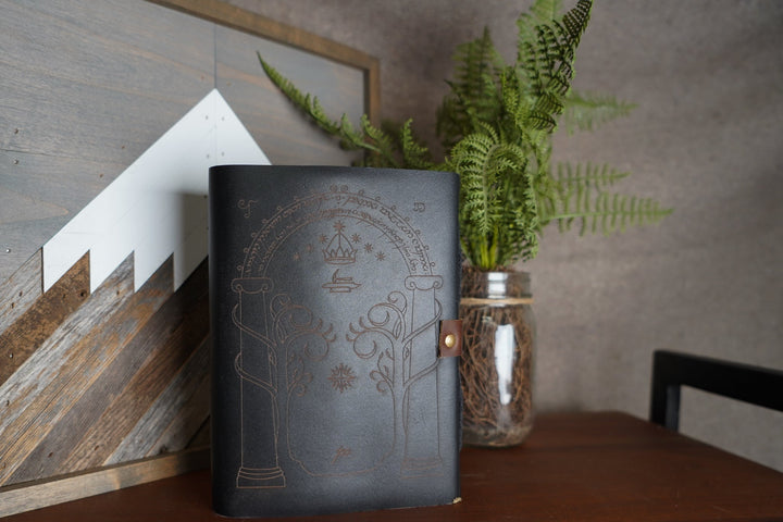 Black leather journal with embossed architectural design and attached wooden pencil