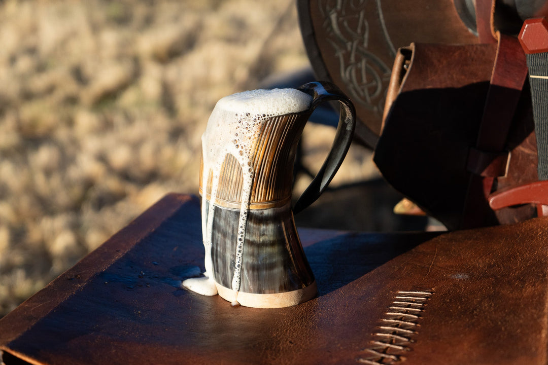 Two-tone horn stein on wooden surface with dark handle and light vertical texture