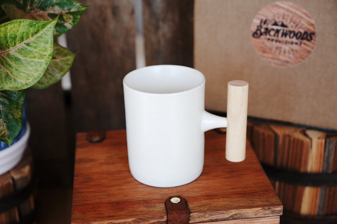White ceramic mug with wooden handle, side view