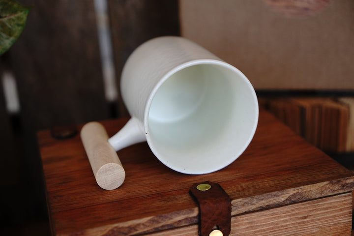 White ceramic mug with wooden handle, top view