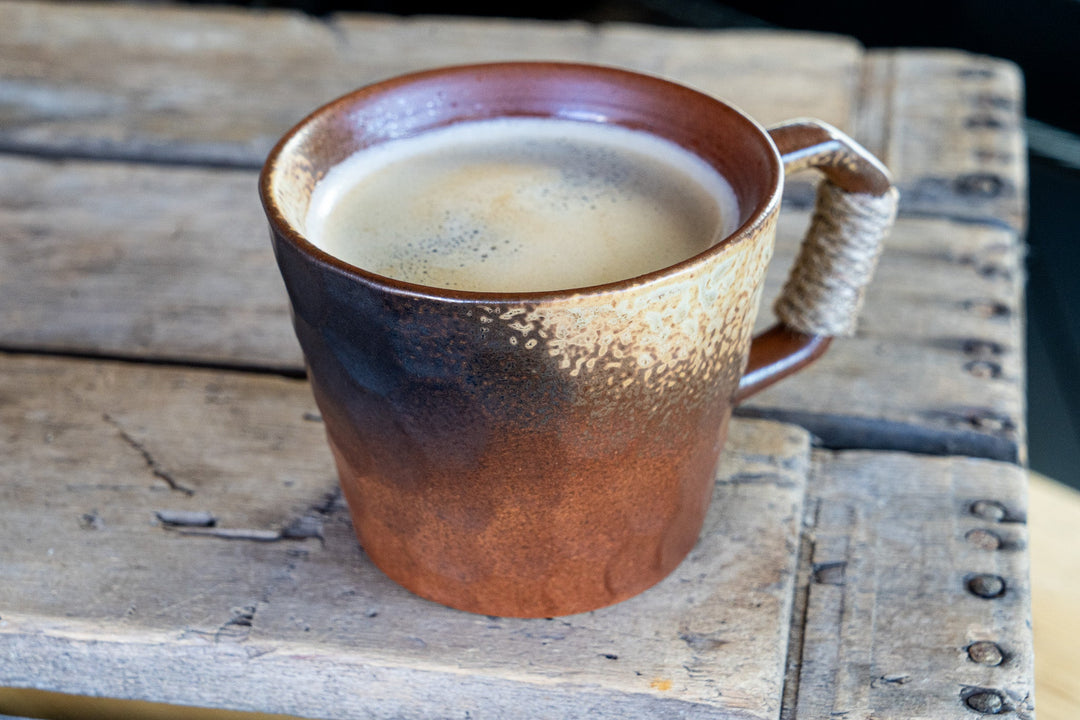 Earthenware coffee mug with speckled glaze and wrapped handle, top view
