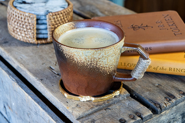 Textured ceramic mug with speckled glaze, wrapped handle, and glazed base