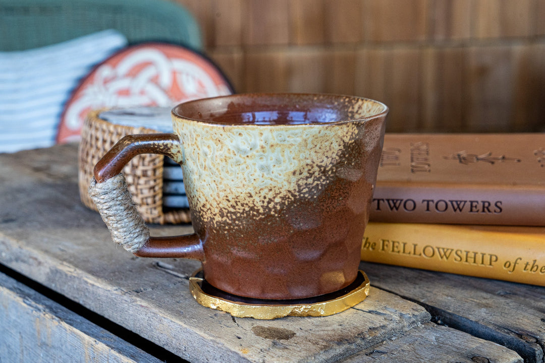 Mottled earth-toned ceramic mug with speckled glaze and wrapped handle
