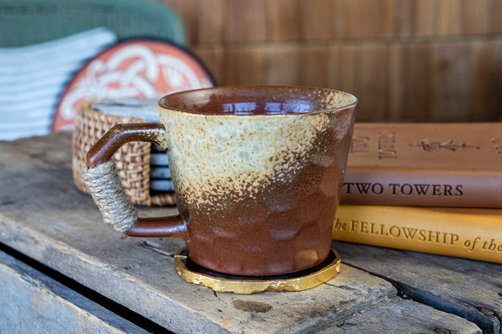 Mottled earth-toned ceramic mug with speckled glaze and wrapped handle