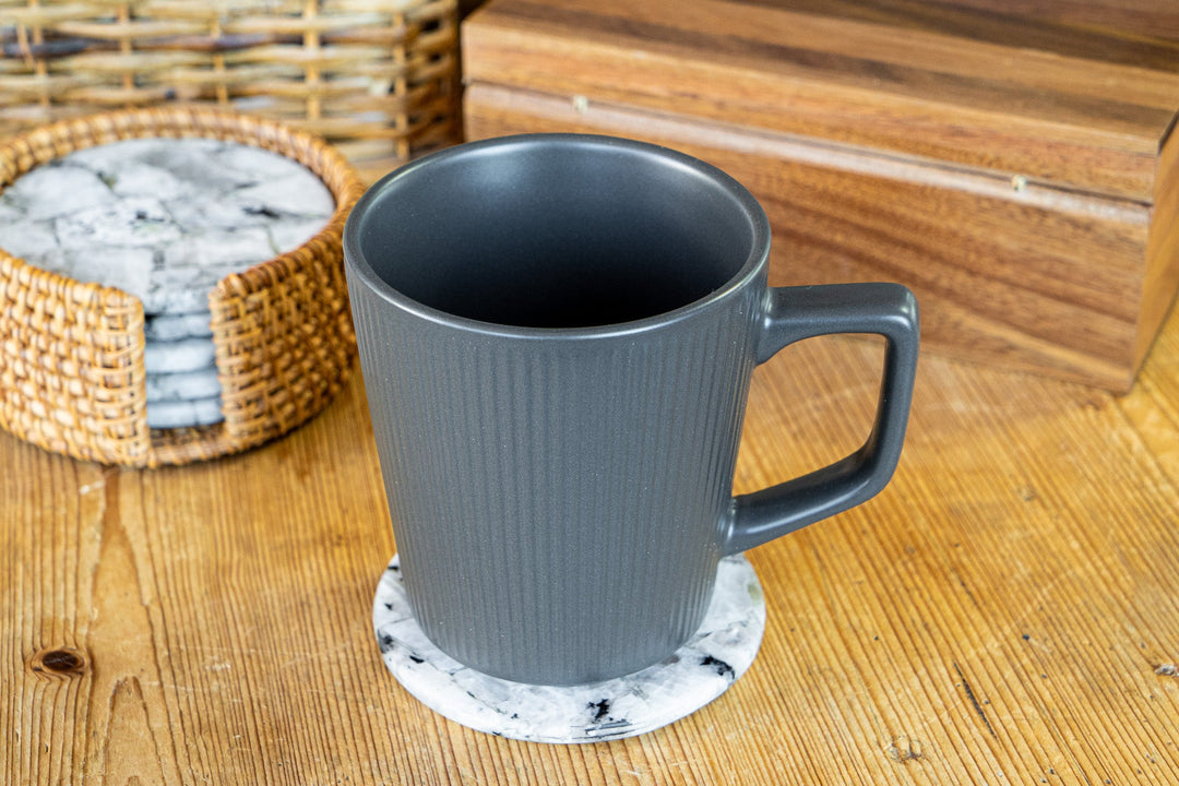 Blue ribbed ceramic mug with handle on tabletop