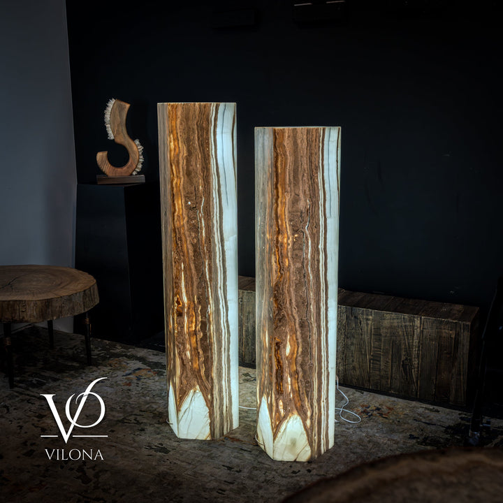 Pair of tall floor lamps with amber-and-white onyx stone columns and warm interior glow