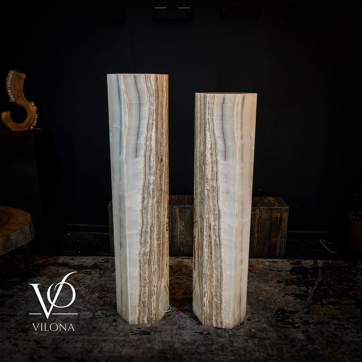 Pair of white onyx floor lamps with vertical brown veining and soft upward illumination