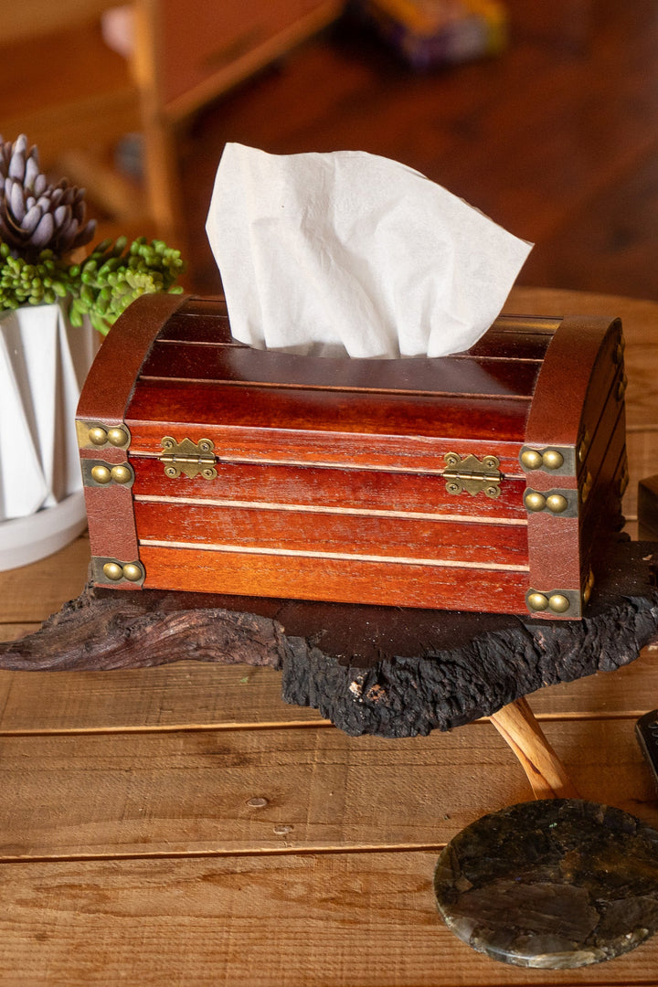 Wooden tissue box with bronze trim and open lid, white tissue emerging