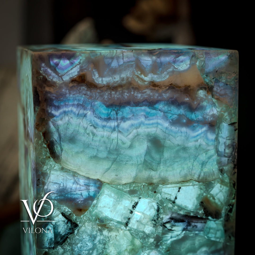 Fluorite crystal table lamp close-up, square teal-blue crystal with dark mineral streaks