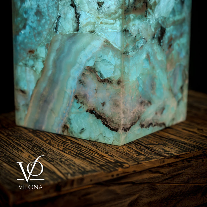 Fluorite crystal table lamp close-up of teal-blue facets and dark inclusions on square base