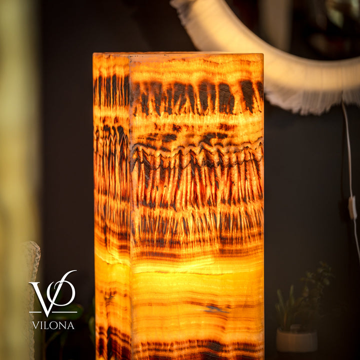 Onyx floor lamp close-up: glowing square shade with golden orange layered design
