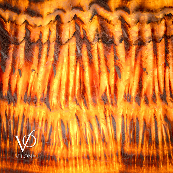 Glowing square lamp shade detail with orange-golden ridges and dark scalloped lines