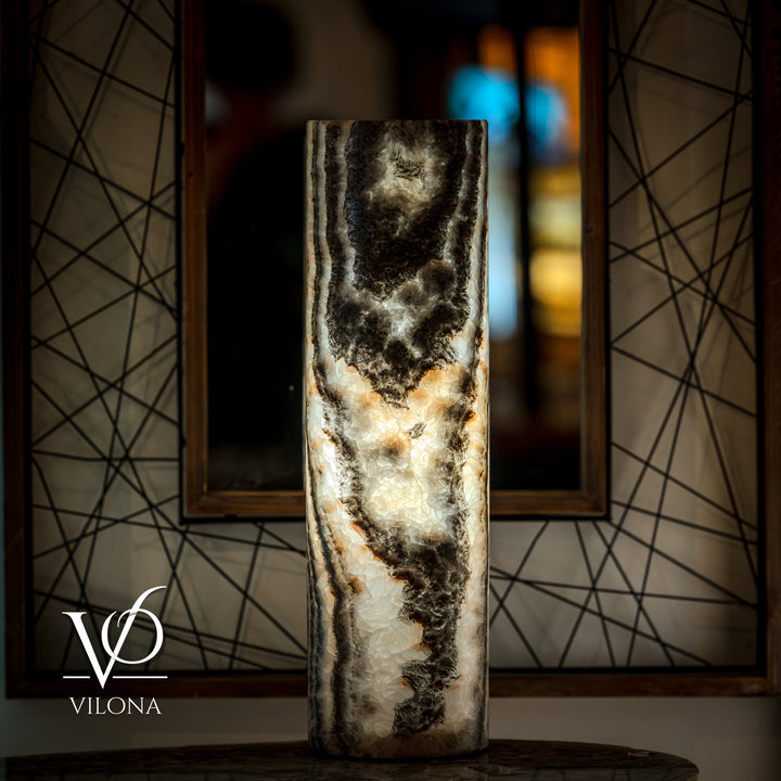Cylindrical onyx table lamp base with dark mottled top and creamy center veining.