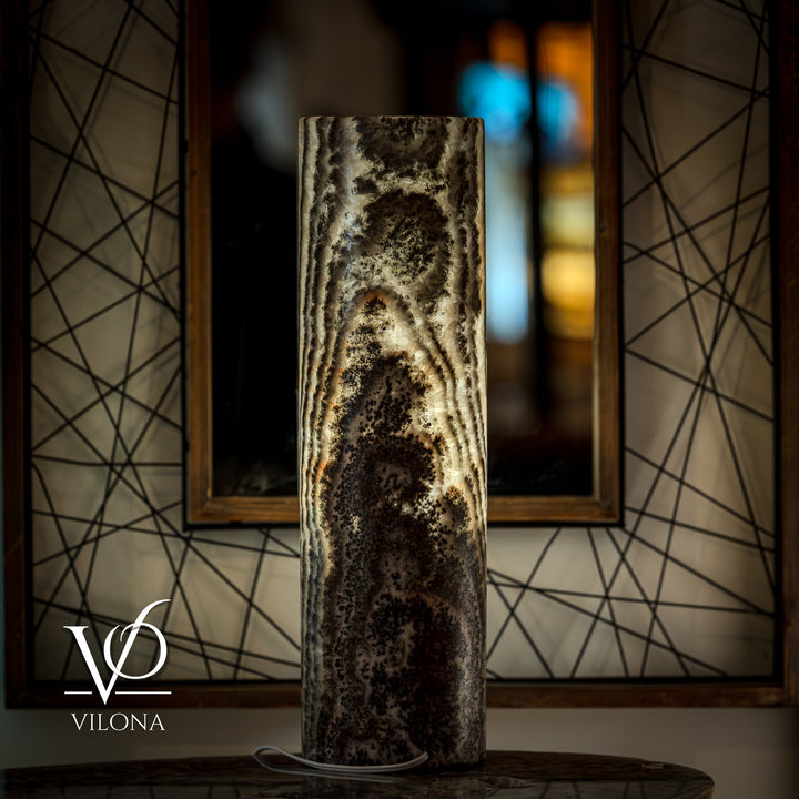 Tall onyx table lamp base with dark shell-like texture and light cream patches.