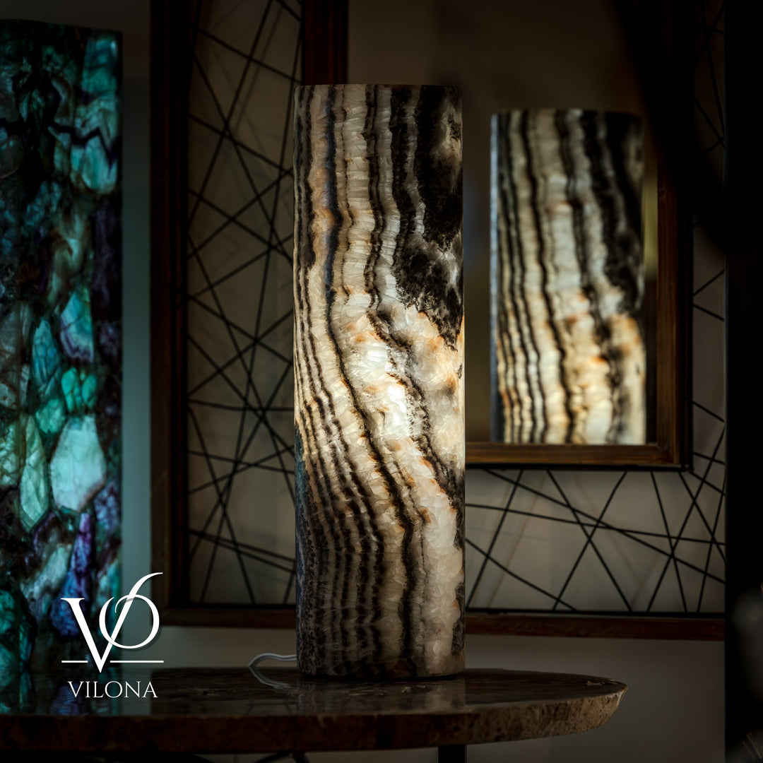 Onyx table lamp base from an angle, showing vertical cream lines over dark stone.