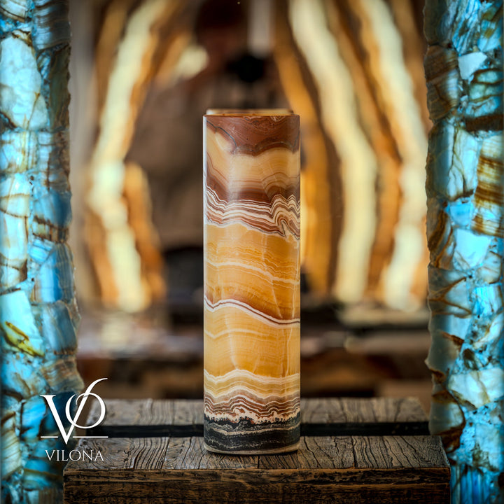 Onyx cylinder table lamp on wooden surface with bright golden glow