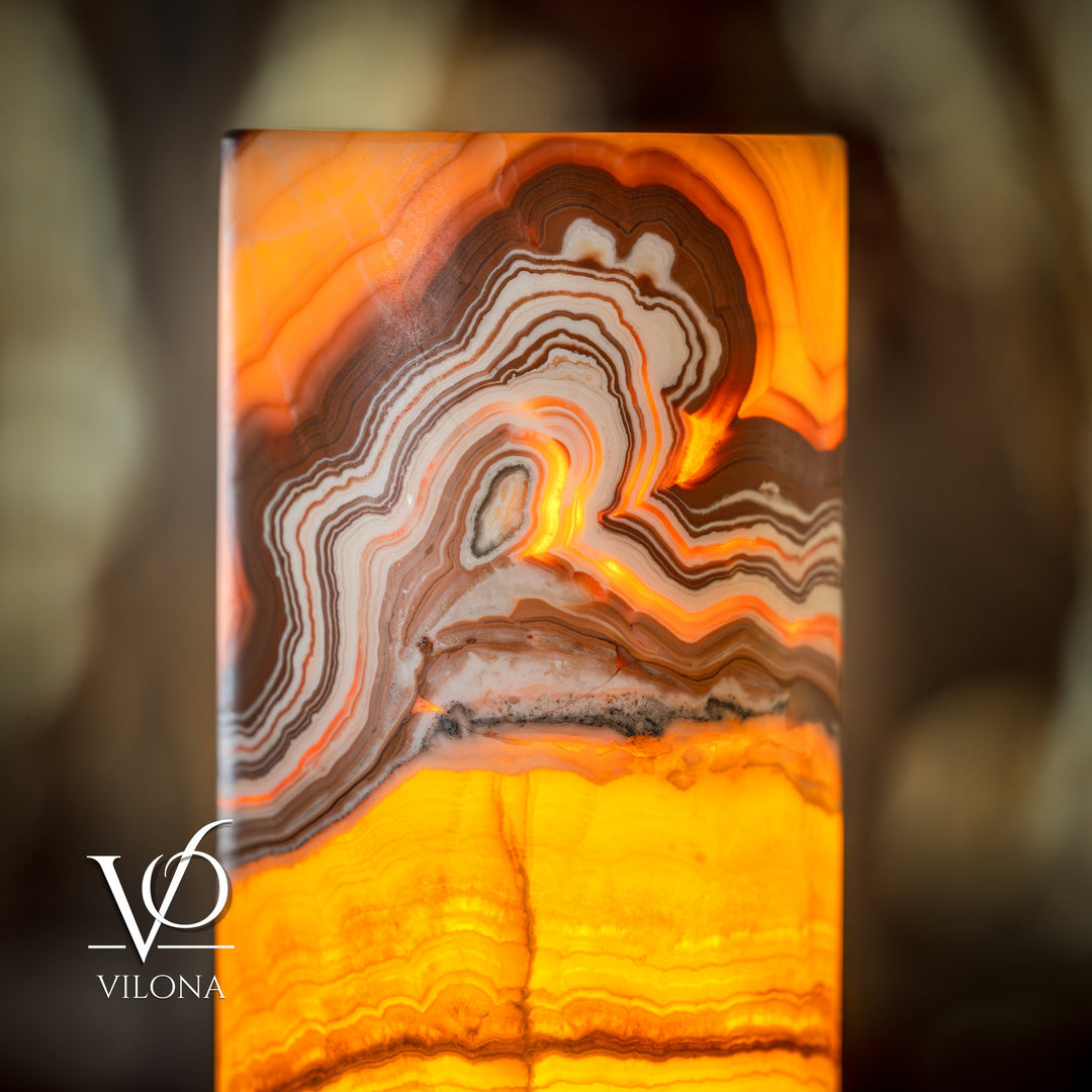 Onyx cylinder lamp shade with glowing orange and amber stone veining, wavy band pattern
