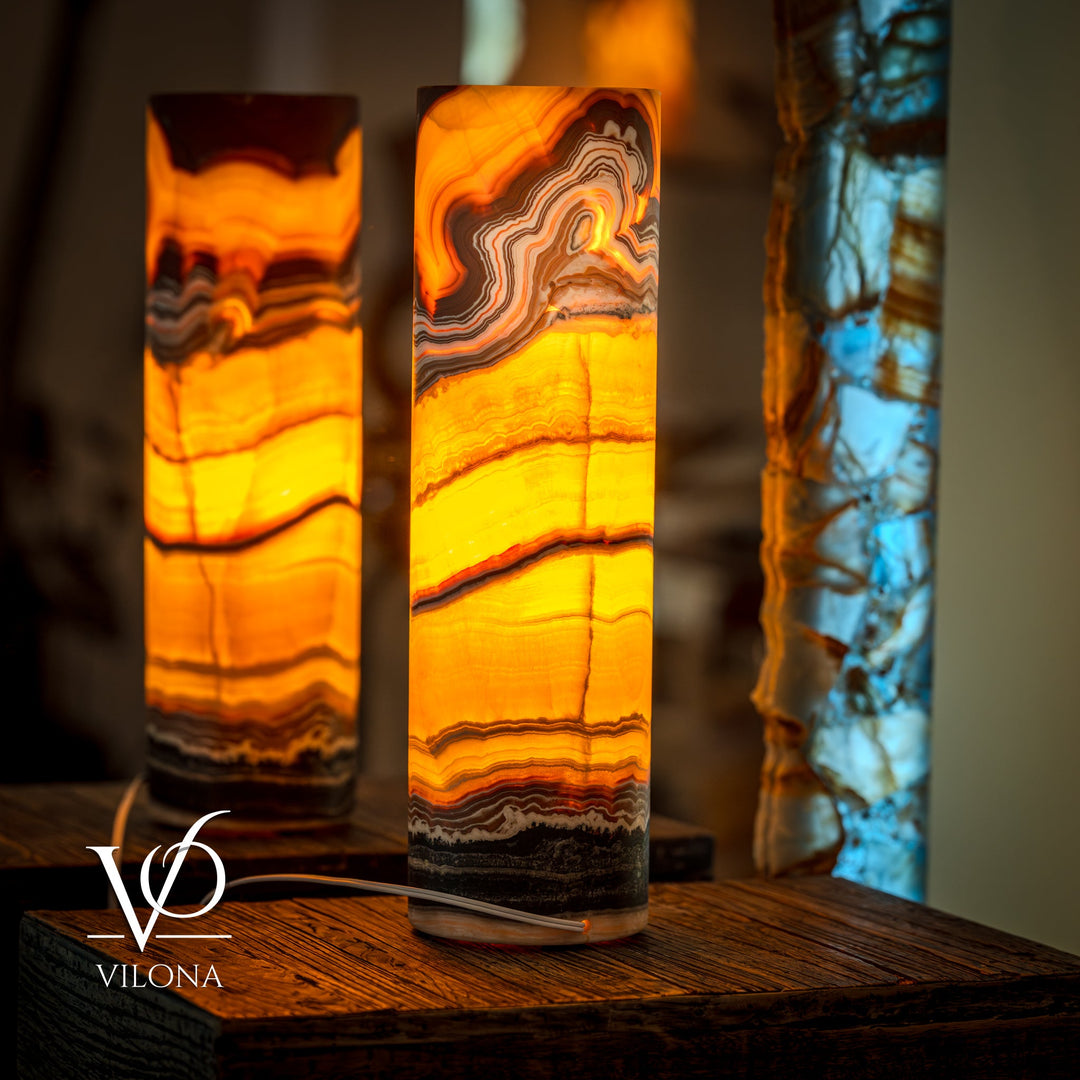Pair of onyx cylinder table lamps with warm amber glow and wavy stone bands