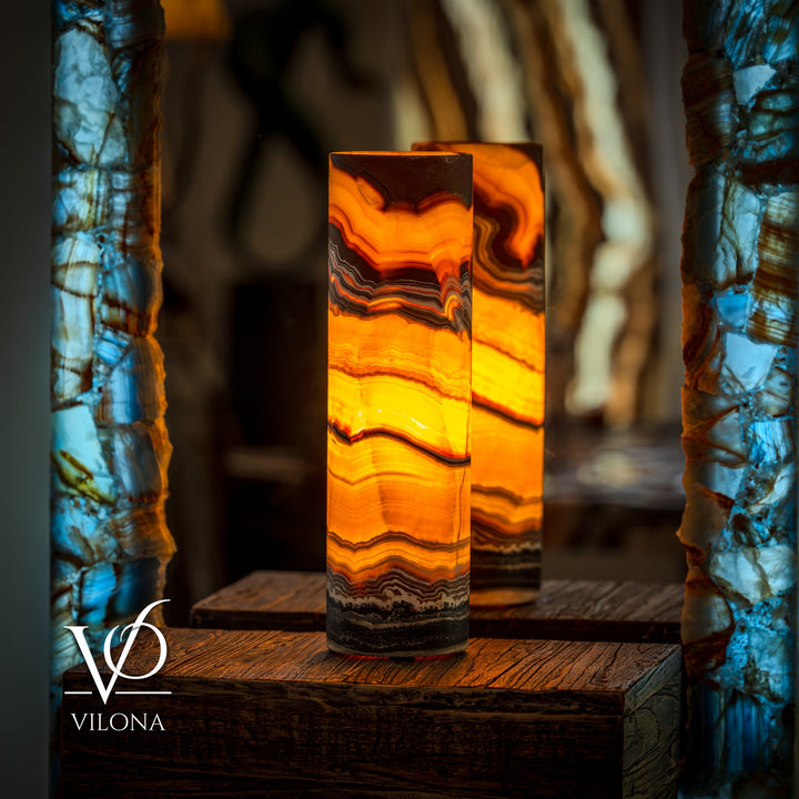 Onyx cylinder table lamp with warm amber glow and layered stone stripes
