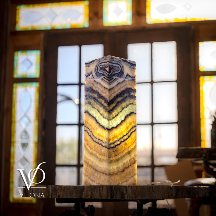 Square table lamp with glowing onyx-style square shade on a dark stone base