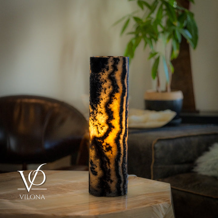 Onyx table lamp with tall cylindrical onyx body, high-contrast veins and warm glowing light