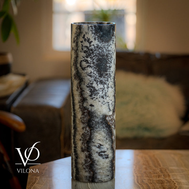 Onyx table lamp with tall cylindrical stone body, speckled gray-and-black marbling, unlit