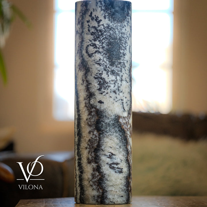 Onyx table lamp with tall cylindrical stone body, light gray speckling and dark veining, unlit