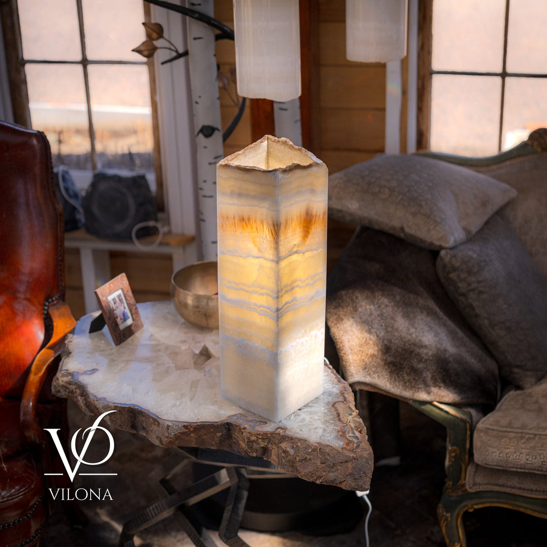 Square onyx table lamp with cream amber-striped shade, on stone side table