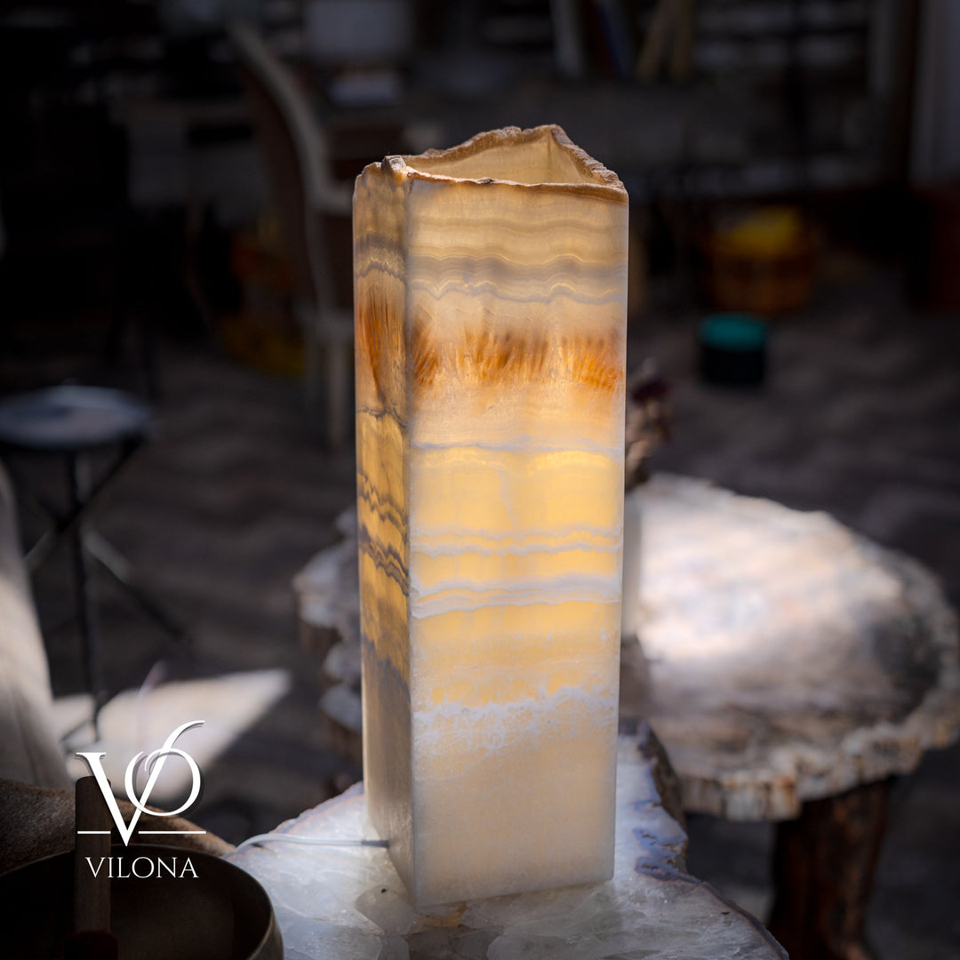 Square onyx table lamp with illuminated cream shade and amber bands, close-up