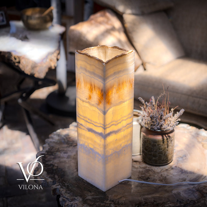 Square onyx-style table lamp with glowing cream shade and visible power cord