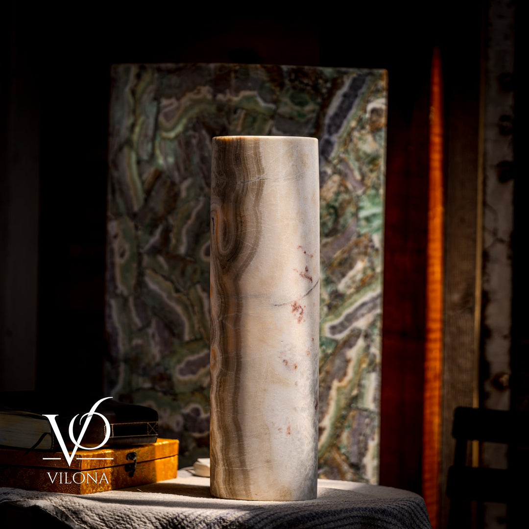 Cream cylindrical stone table lamp with dark swirling patterns; tall drum-style shade.