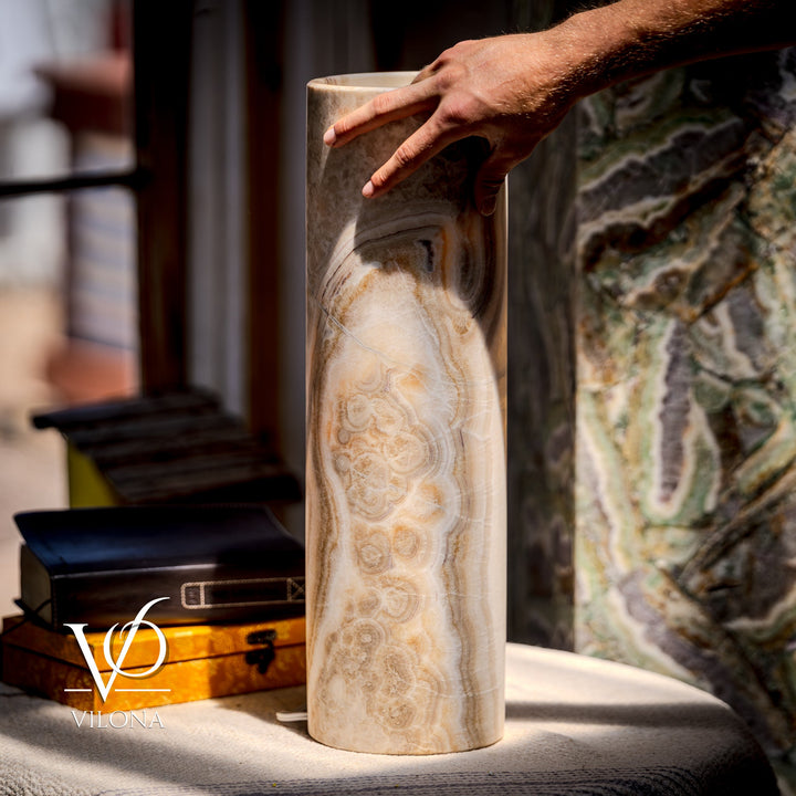 Cream cylindrical stone table lamp with veined gray-brown swirls; tall drum shape.