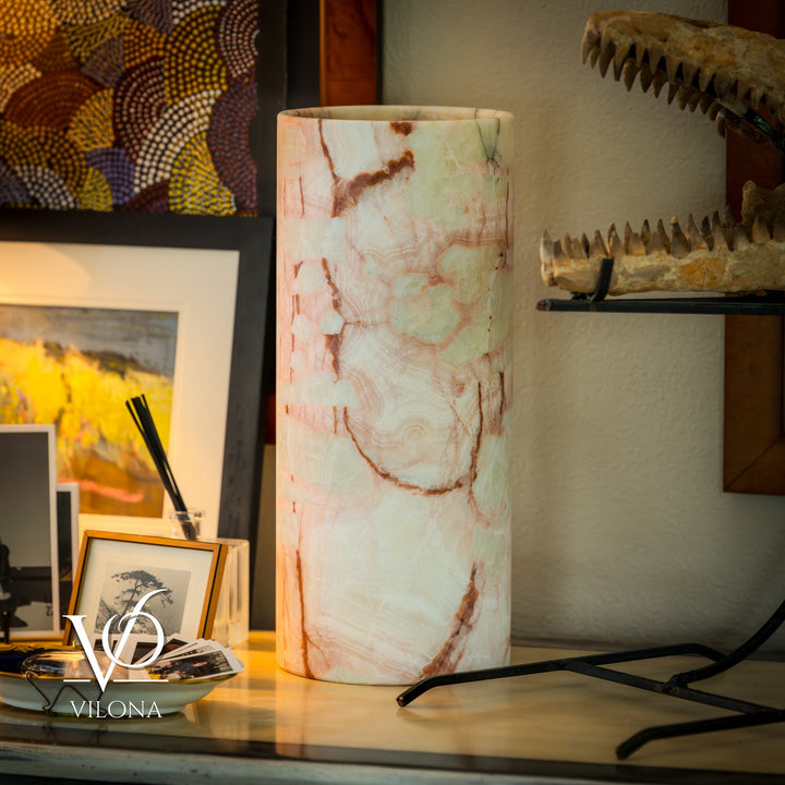 Table lamp with tall off-white cylindrical shade and warm marbled veining.
