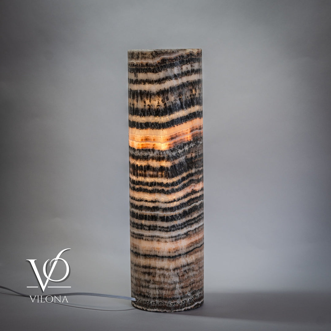 Cylindrical onyx table lamp base with layered black, beige, and cream wave stripes