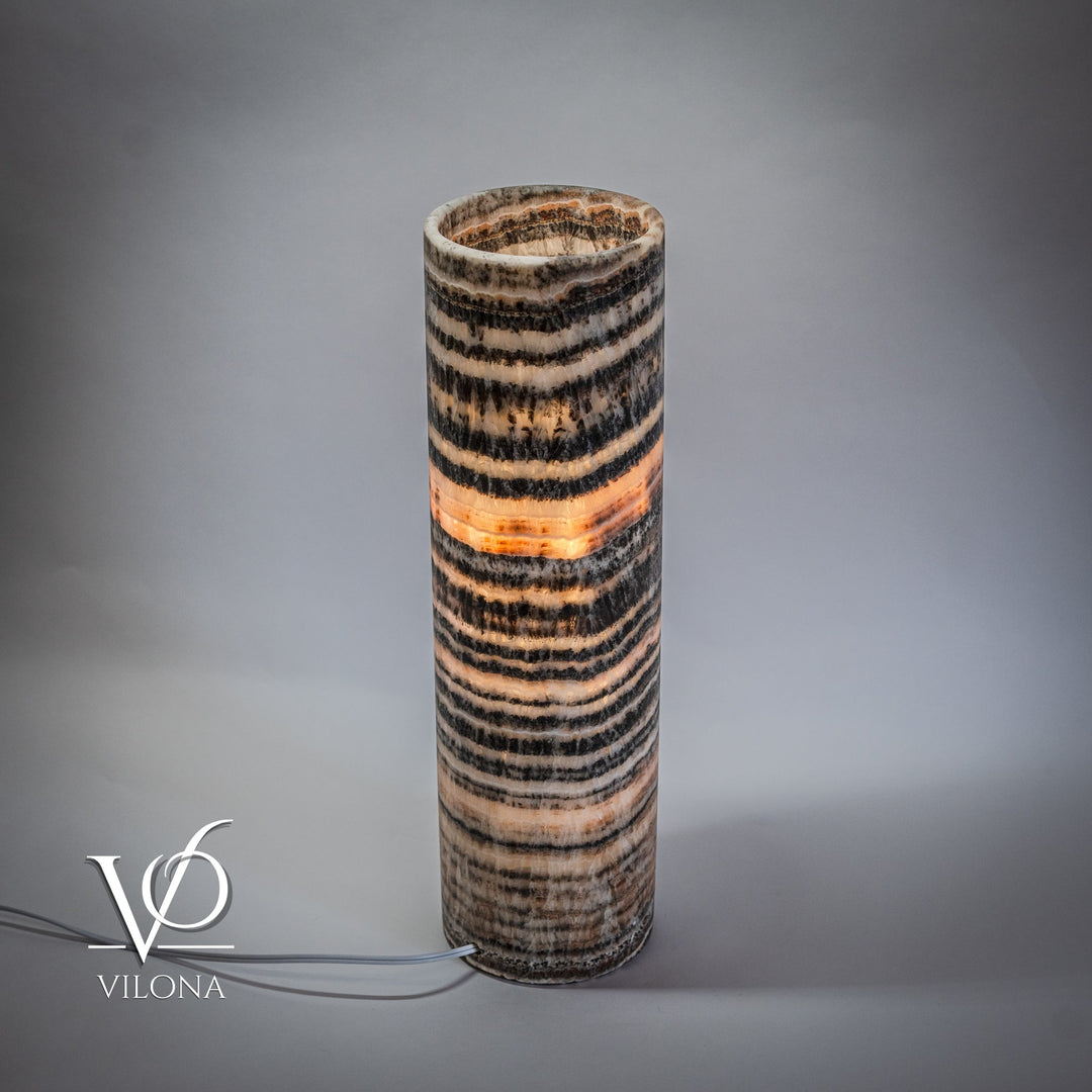 Onyx table lamp base, cylindrical with stacked black and cream stripes, warm glow