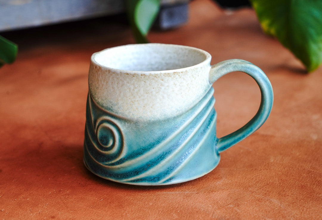 Teal blue ceramic wave mug with swirl design and curved handle