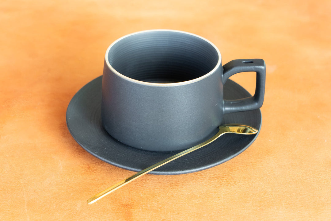 Matte blue bistro mug on saucer with gold spoon