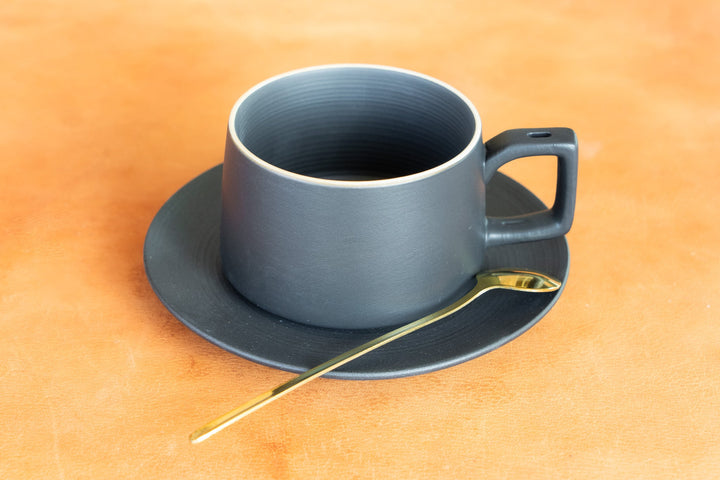 Matte blue bistro mug on saucer with gold spoon