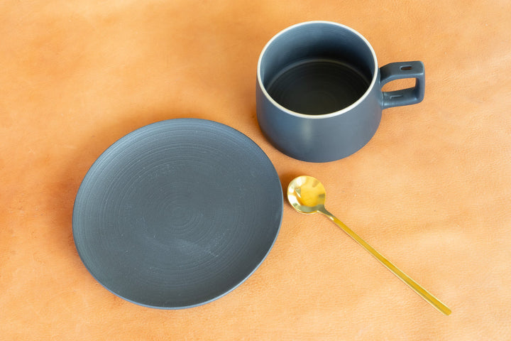 Matte blue bistro mug with saucer and gold spoon, top view