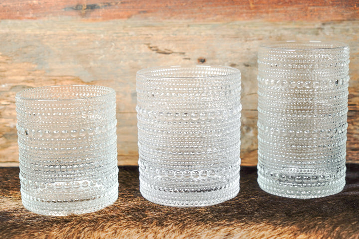 Three clear bubbled glass cylinder cups in different heights with horizontal bead rows