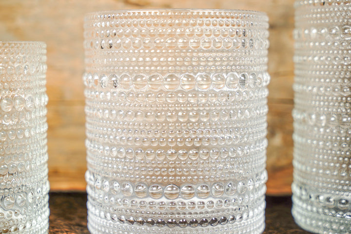 Close-up of clear bubbled glass cup with horizontal bands of raised bead details