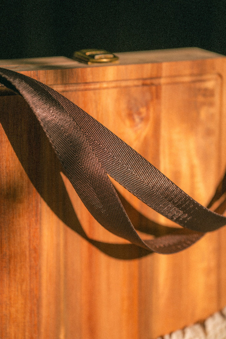Wooden folding cheese board with black webbing carrying handles